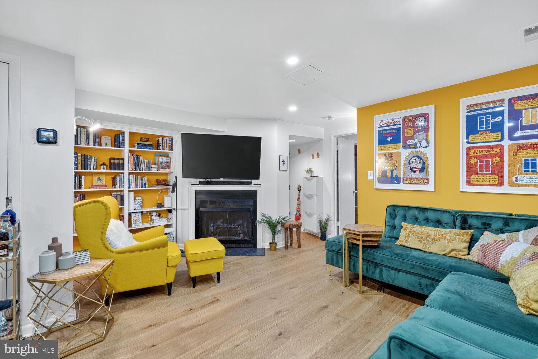 a living room with furniture and a flat screen tv with wooden floor