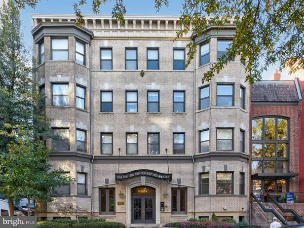 a front view of a residential apartment building with a yard
