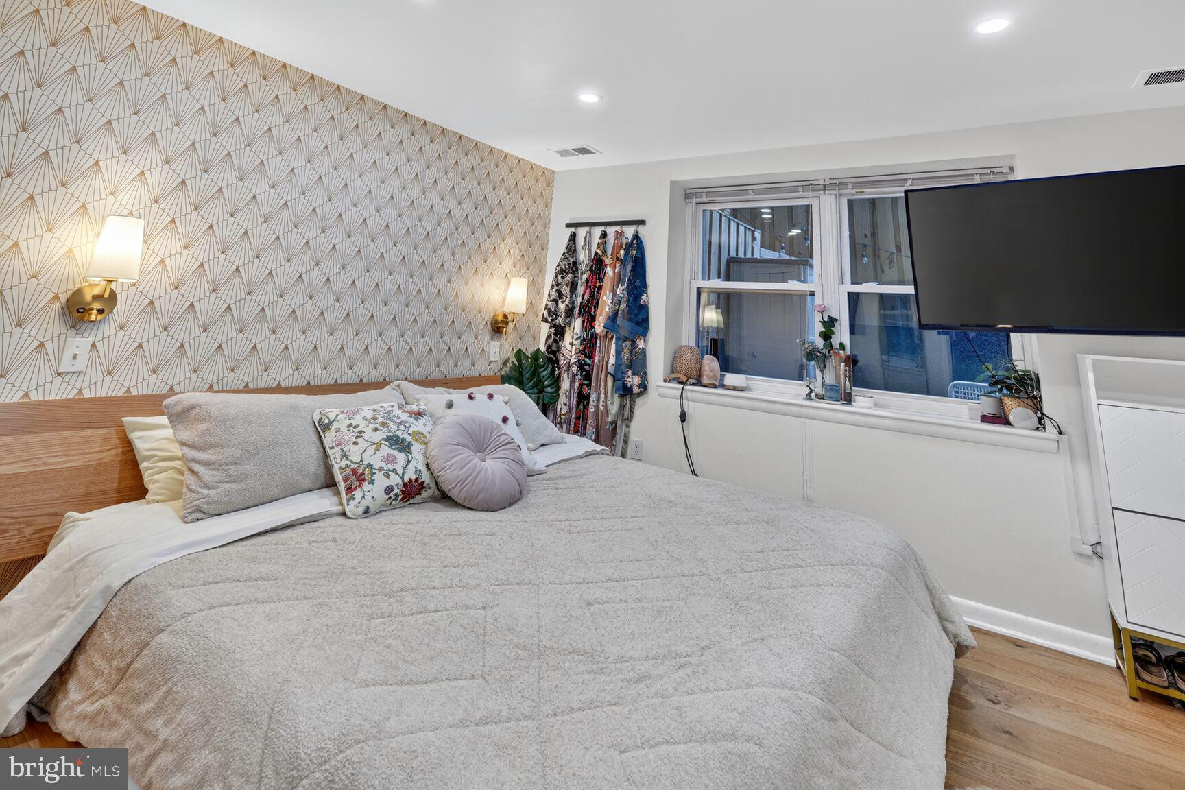2012 O Street Northwest, Unit 12 Washington, DC 20036 - Photo 12 of 16 a bedroom with a bed and a flat tv screen on dresser