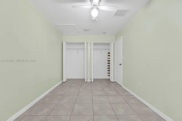an empty room with fan and entrance
