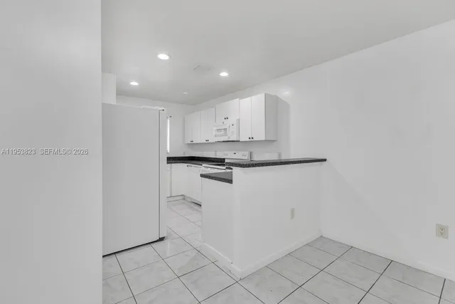a view of kitchen with white cabinets