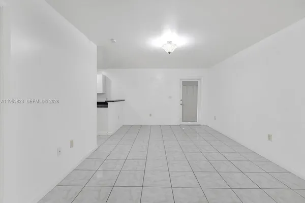 an empty room with white walls and tiles
