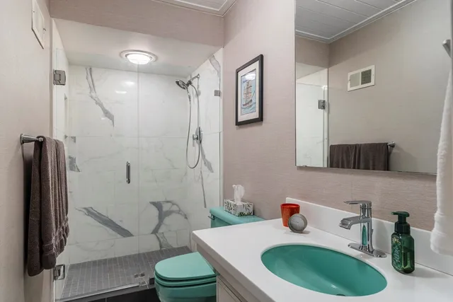 a bathroom with a sink a toilet and shower