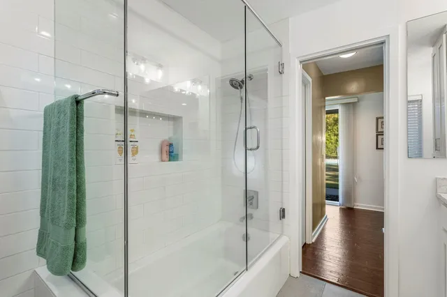 a bathroom with a glass shower door and a sink