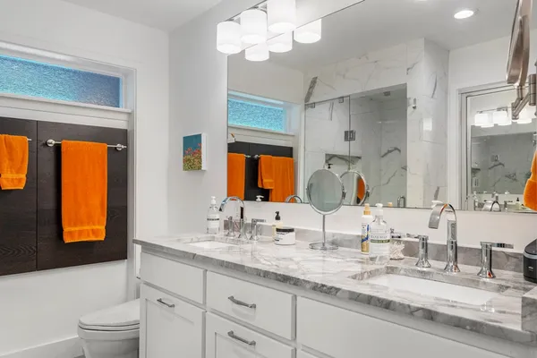 a bathroom with a granite countertop sink mirror and window