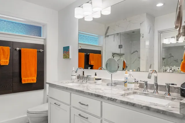 a bathroom with a granite countertop sink mirror and window