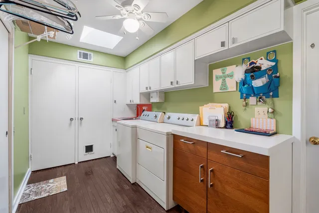 a kitchen with stainless steel appliances a white cabinets and wooden floor