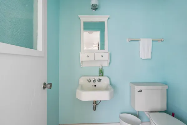 a bathroom with a toilet sink and mirror