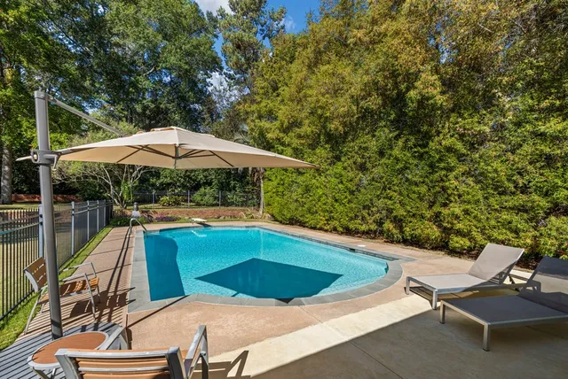 a view of backyard with swimming pool and outdoor seating