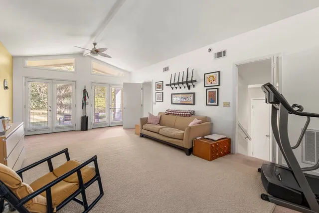 a living room with furniture a flat screen tv and a window