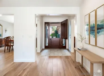 a view of a hallway with wooden floor and furniture