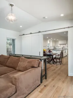 a living room with furniture and a dining table with wooden floor