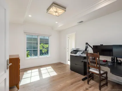 a view of a workspace with furniture and a window