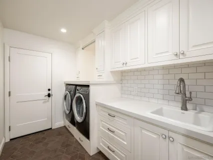 a utility room with sink dryer and washer