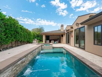 a view of house and swimming pool with seating space