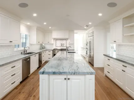 a kitchen with granite countertop kitchen island a sink appliances and cabinets