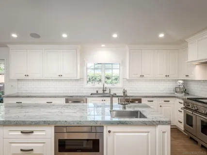 a kitchen with stainless steel appliances granite countertop a sink stove and cabinets
