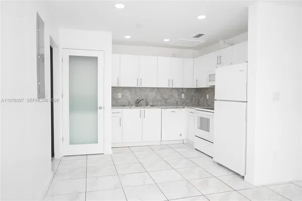 a view of kitchen with white cabinets