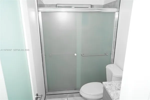 a white toilet sitting next to a shower