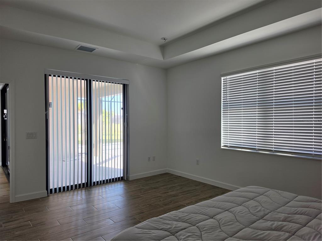 18334 Ridgeline Drive Estero, FL 33928 - Photo 12 of 30 an empty room with wooden floor and windows