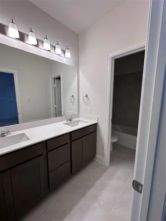 a spacious bathroom with double vanity and a mirror