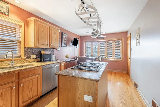 a kitchen with stainless steel appliances granite countertop a sink stove and cabinets