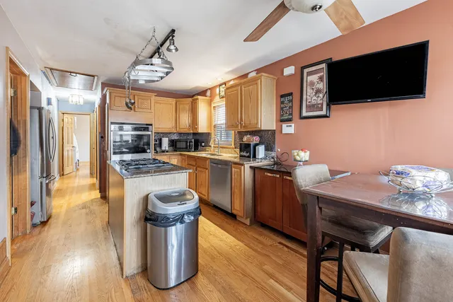 a kitchen with a table chairs refrigerator and microwave
