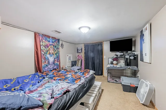 a bedroom with bed and a flat screen tv