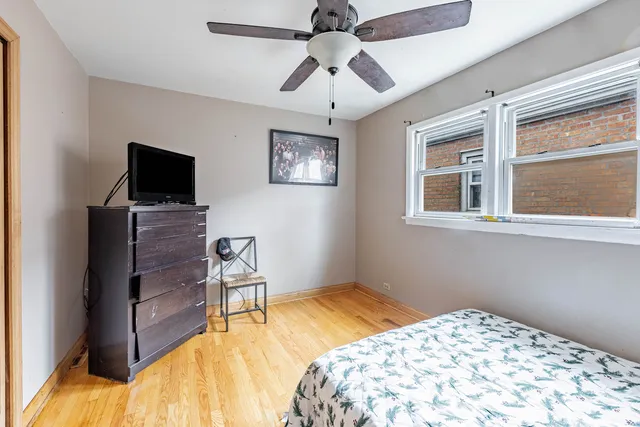 a bedroom with a bed and a flat tv screen on the dresser