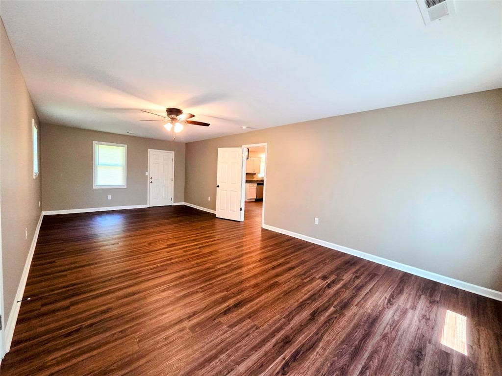 509 Elrod Road Piedmont, SC 29673 - Photo 24 of 28 Rich wood flooring stretches across this well-lit living area, creating an inviting atmosphere.