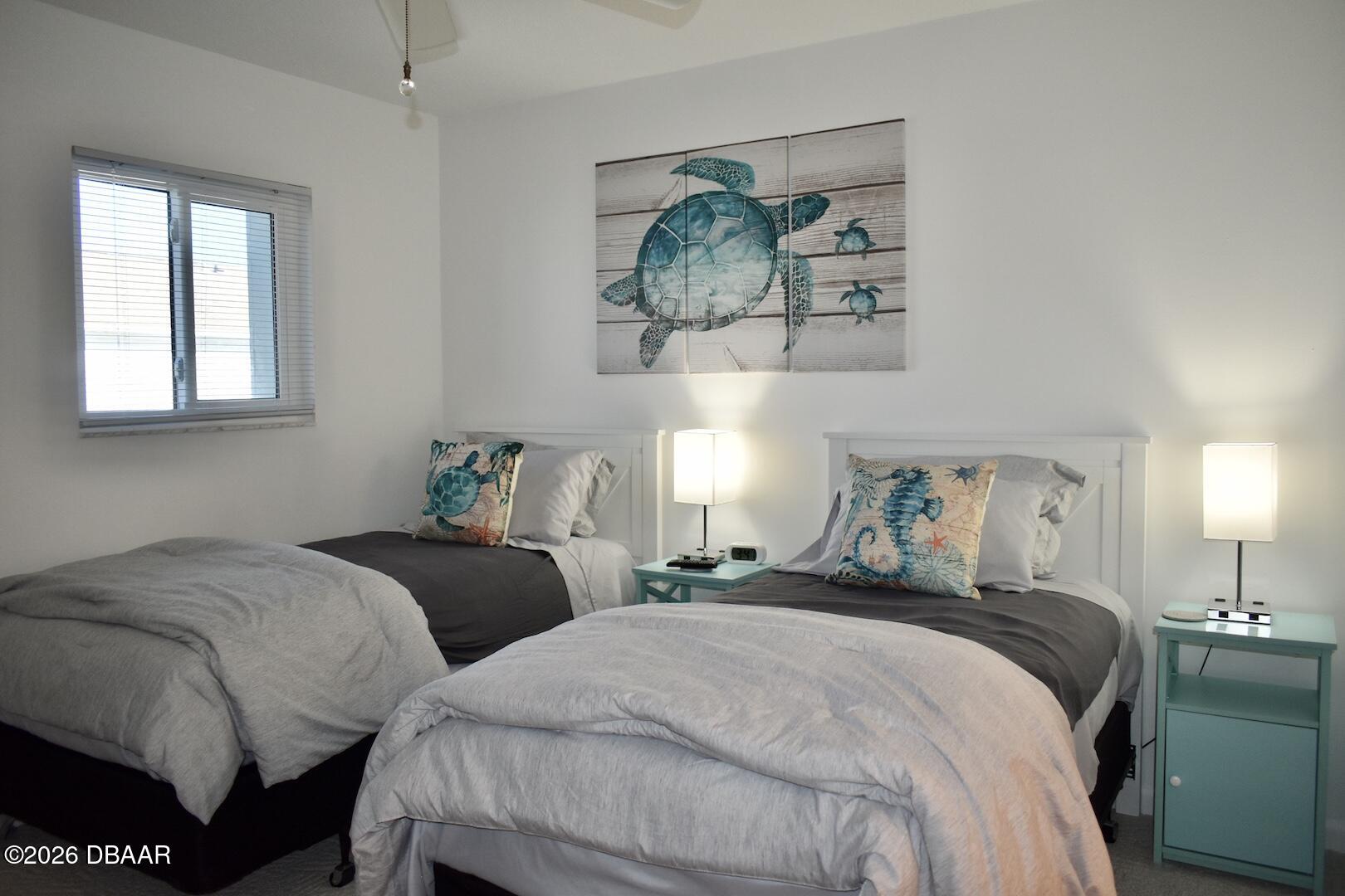 4790 South Atlantic Avenue, Unit F602 Ponce Inlet, FL 32127 - Photo 12 of 23 a bedroom with two beds and a painting on the wall