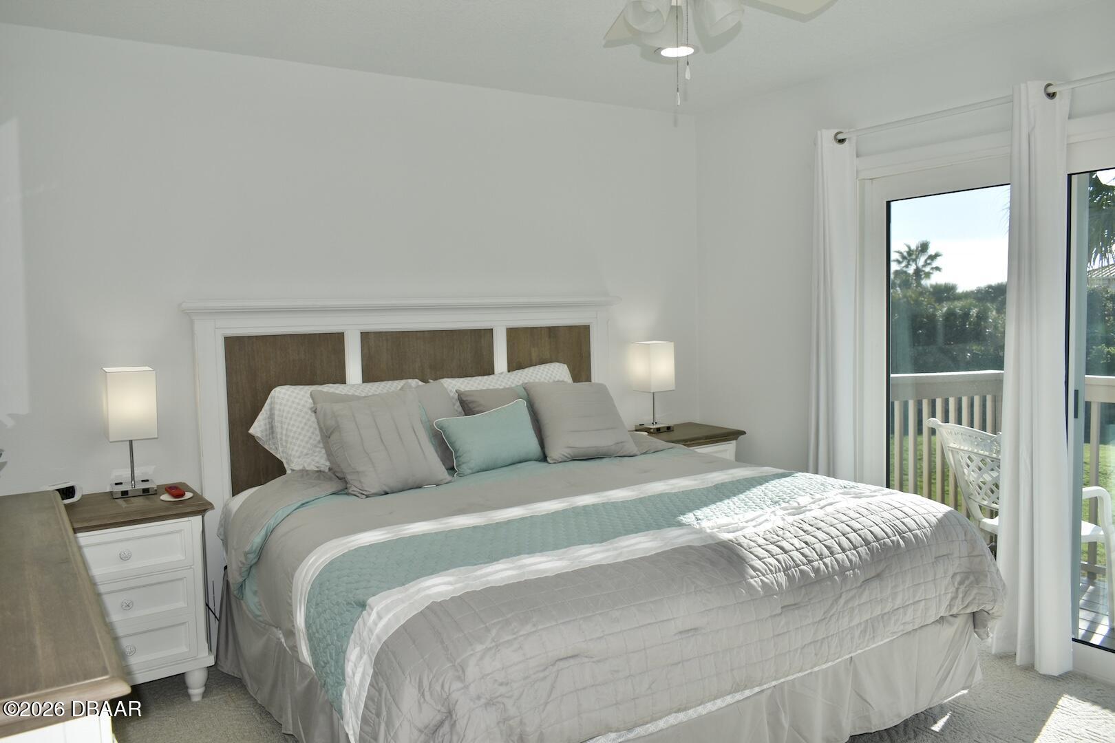 4790 South Atlantic Avenue, Unit F602 Ponce Inlet, FL 32127 - Photo 16 of 23 a bedroom with a bed and a lamp