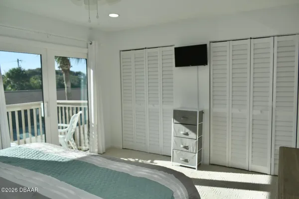 a view of a bedroom with a flat tv screen and a sink