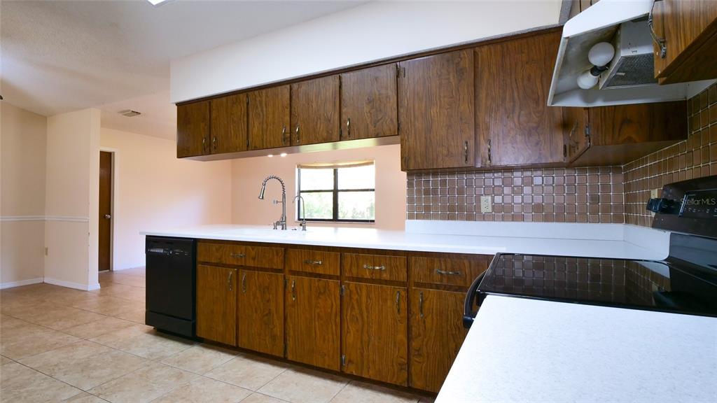 10960 Echo Loop New Port Richey, FL 34654 - Photo 12 of 38 a kitchen with stainless steel appliances a sink and cabinets