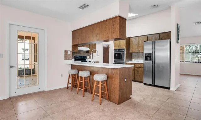 a kitchen with stainless steel appliances granite countertop a refrigerator and a stove top oven