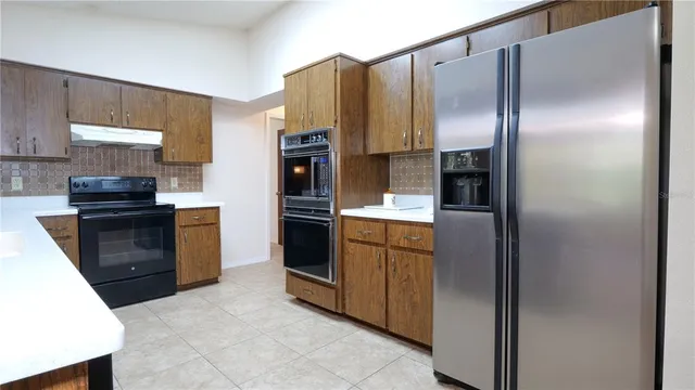 a kitchen with stainless steel appliances granite countertop a refrigerator and a stove