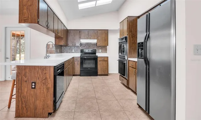a kitchen with stainless steel appliances a sink and cabinets