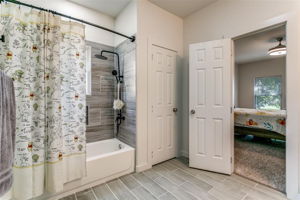 1108 South Morris Street Gainesville, TX 76240 - Photo 14 of 23 a bathroom with a bathtub and a shower