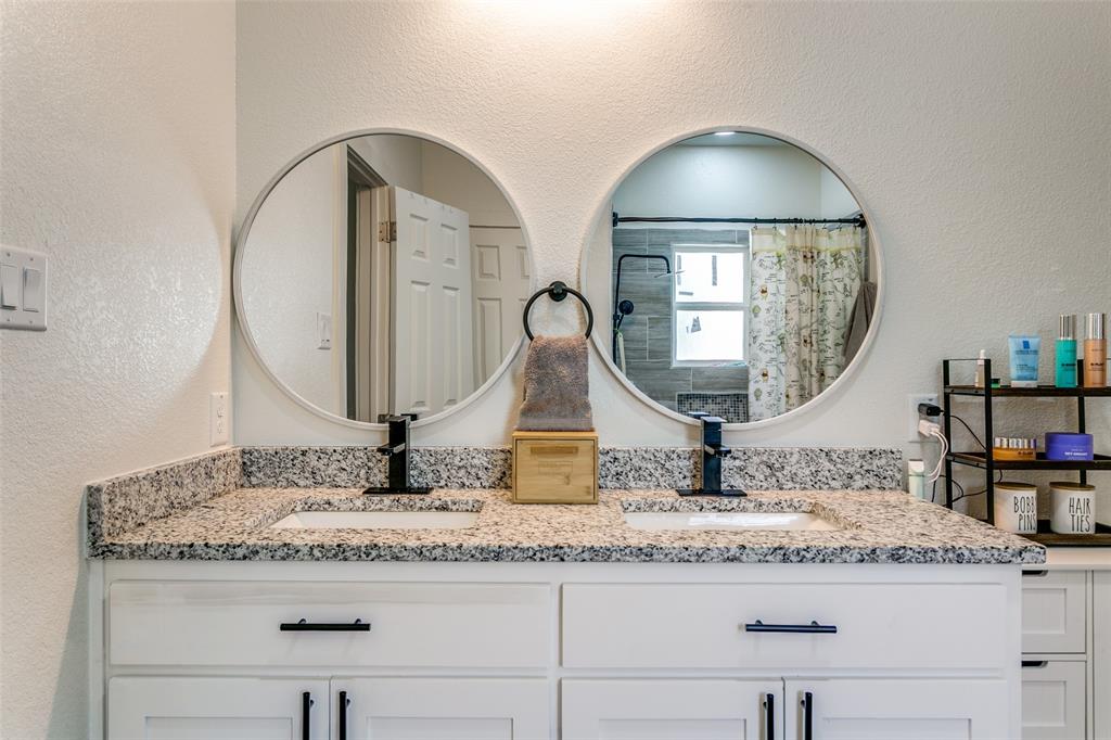 1108 South Morris Street Gainesville, TX 76240 - Photo 15 of 23 a bathroom with a granite countertop sink and a mirror