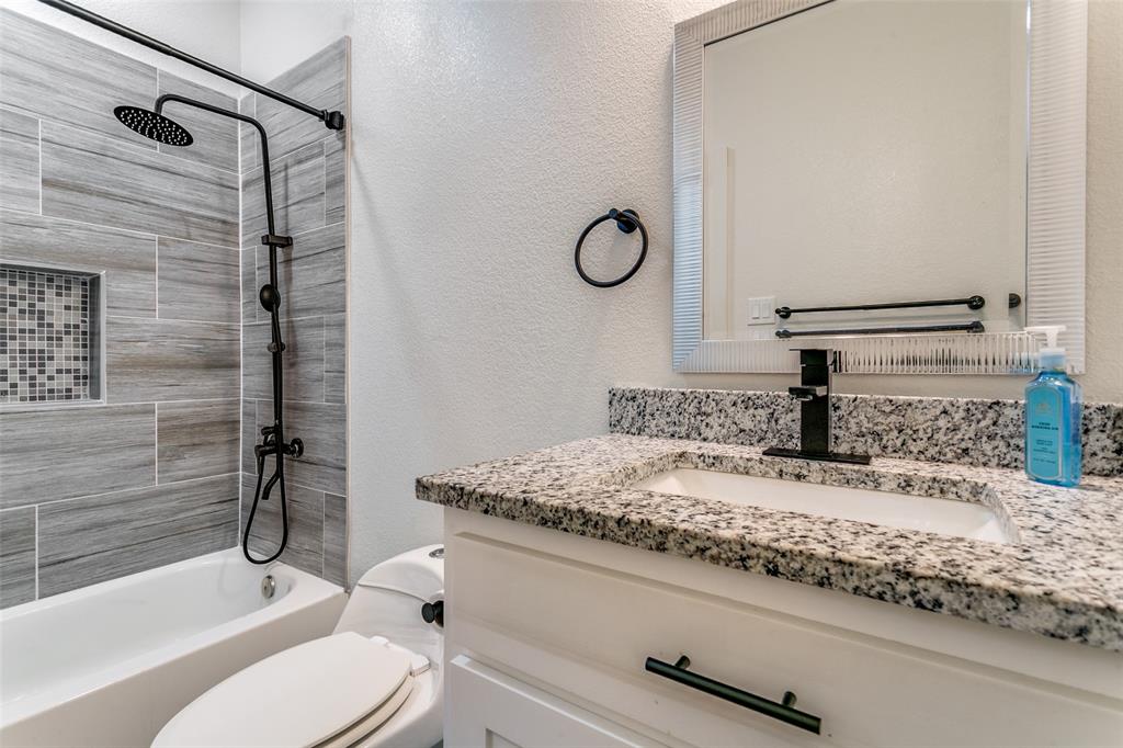 1108 South Morris Street Gainesville, TX 76240 - Photo 19 of 23 a bathroom with a granite countertop sink toilet and shower