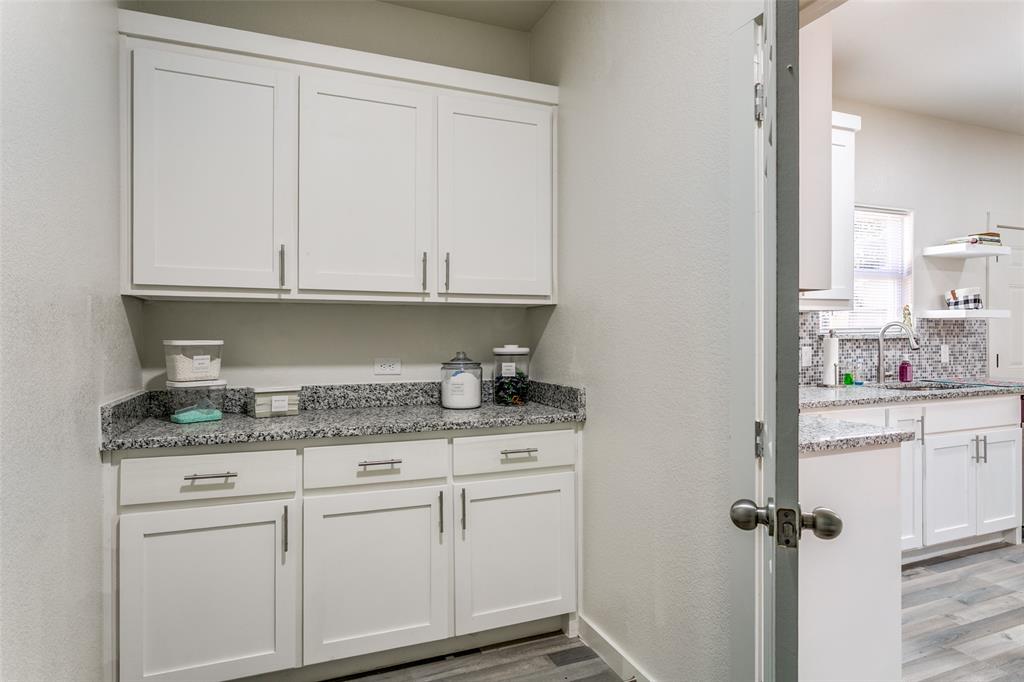 1108 South Morris Street Gainesville, TX 76240 - Photo 20 of 23 a kitchen with granite countertop white cabinets and white appliances