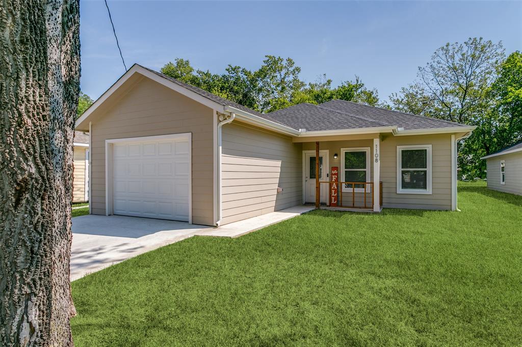 1108 South Morris Street Gainesville, TX 76240 - Photo 2 of 23 a front view of a house with a yard and garage