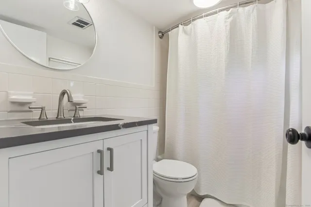a bathroom with a sink a toilet and a mirror