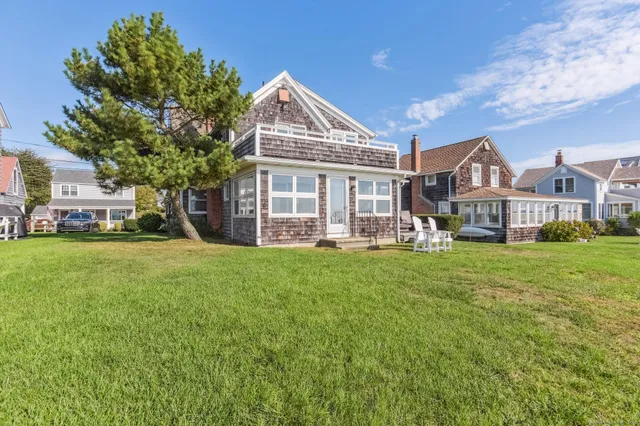 a view of a house with a big yard and large trees