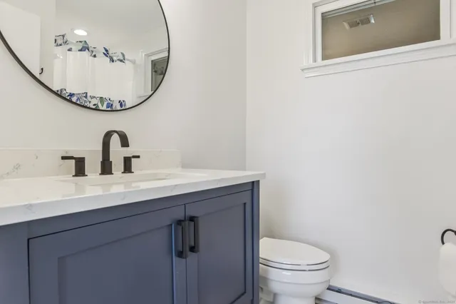 a bathroom with a sink mirror and toilet