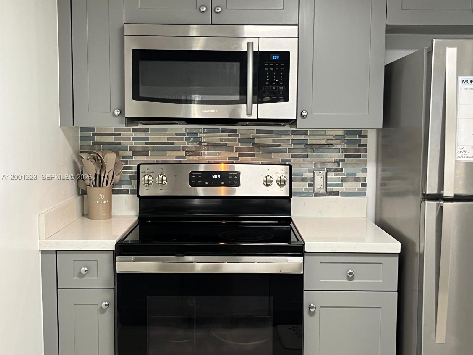 280 Southwest 20th Road, Unit 504 Miami, FL 33129 - Photo 12 of 23 a kitchen with microwave cabinets and stove top oven