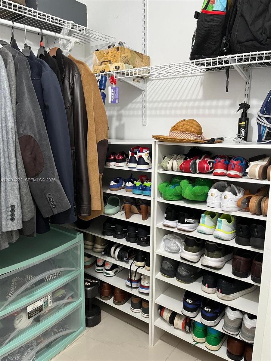 280 Southwest 20th Road, Unit 504 Miami, FL 33129 - Photo 16 of 23 a view of walk in closet with clothes and shoes