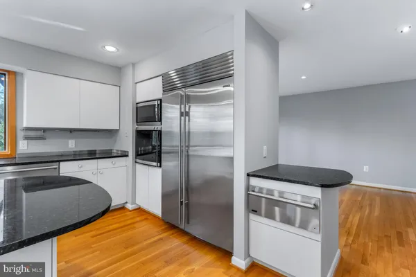 a large kitchen with stainless steel appliances kitchen island a large counter top a stove and a refrigerator