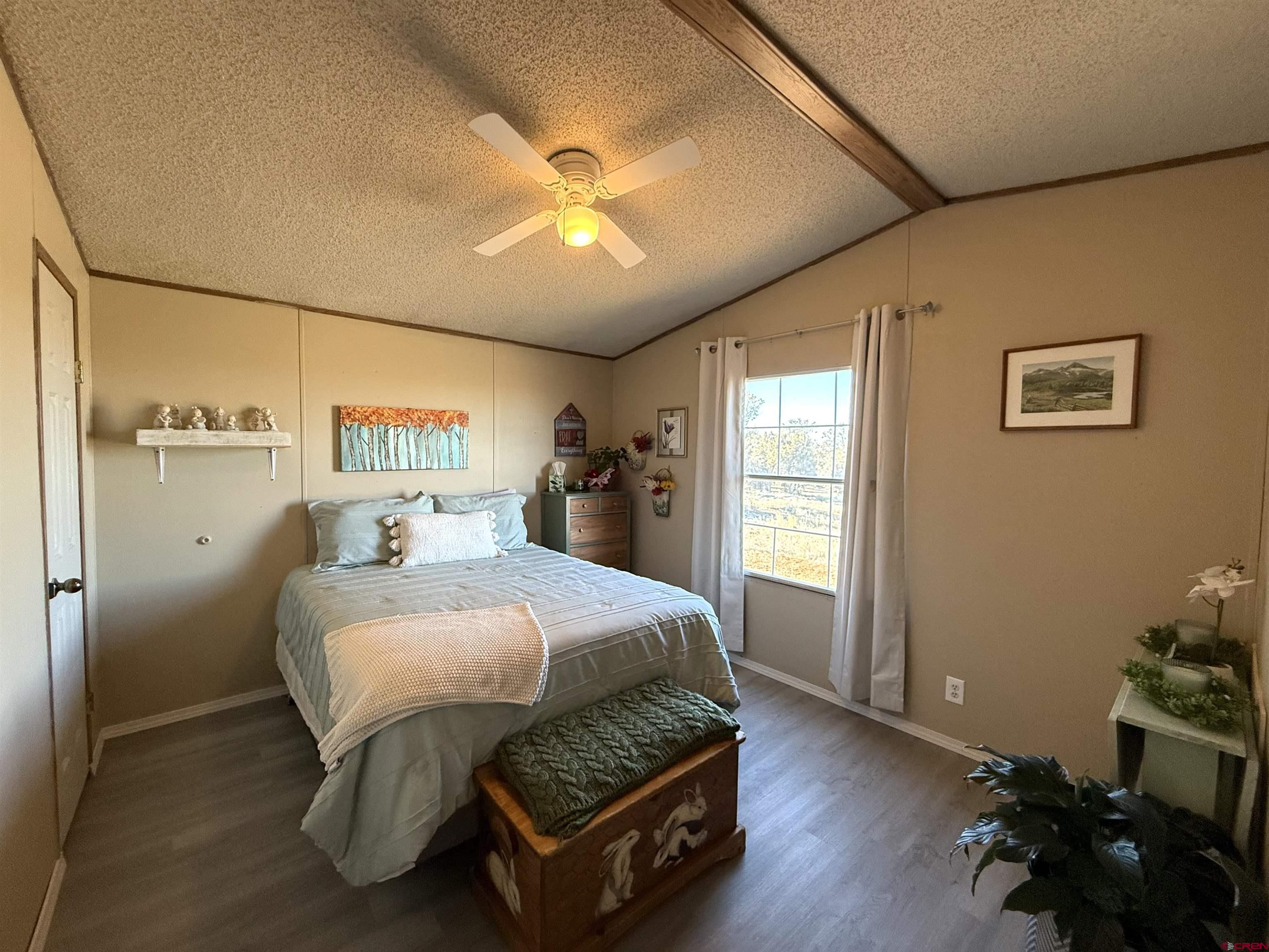 15546 Rd BB Pleasant View, CO 81331 - Photo 16 of 29 a bedroom with a bed and wooden floor