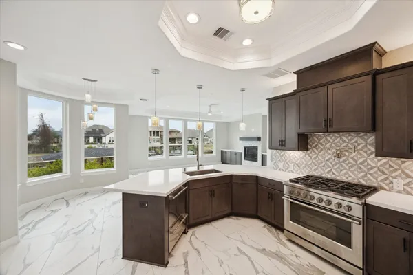 a kitchen with granite countertop a refrigerator stove and cabinets